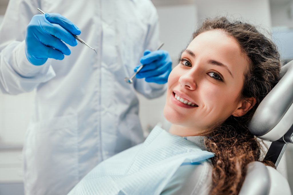 Mujer sonriendo en consultorio dental con resinas dentales