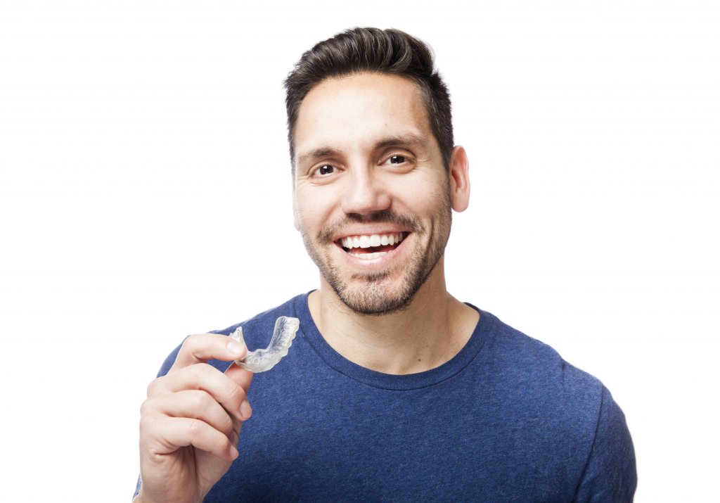 Persona con un retenedor dental invisalign en la mano