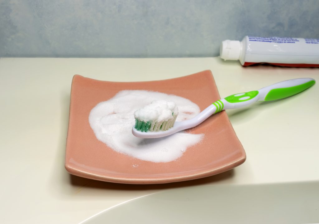 Cepillo dental con bicarbonato de sodio y pasta dental para blanqueamiento dental casero.