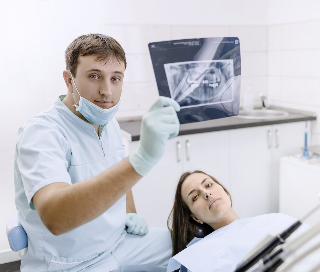 Dentista mostrando una placa panorámica dental