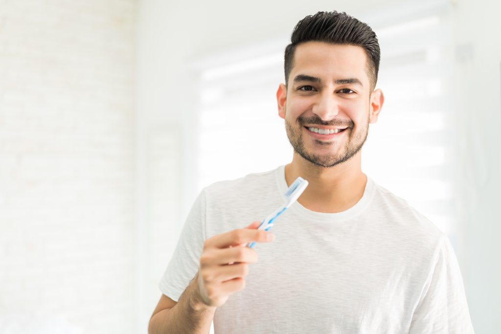 Persona lavándose los dientes para evitar una extracción de muelas
