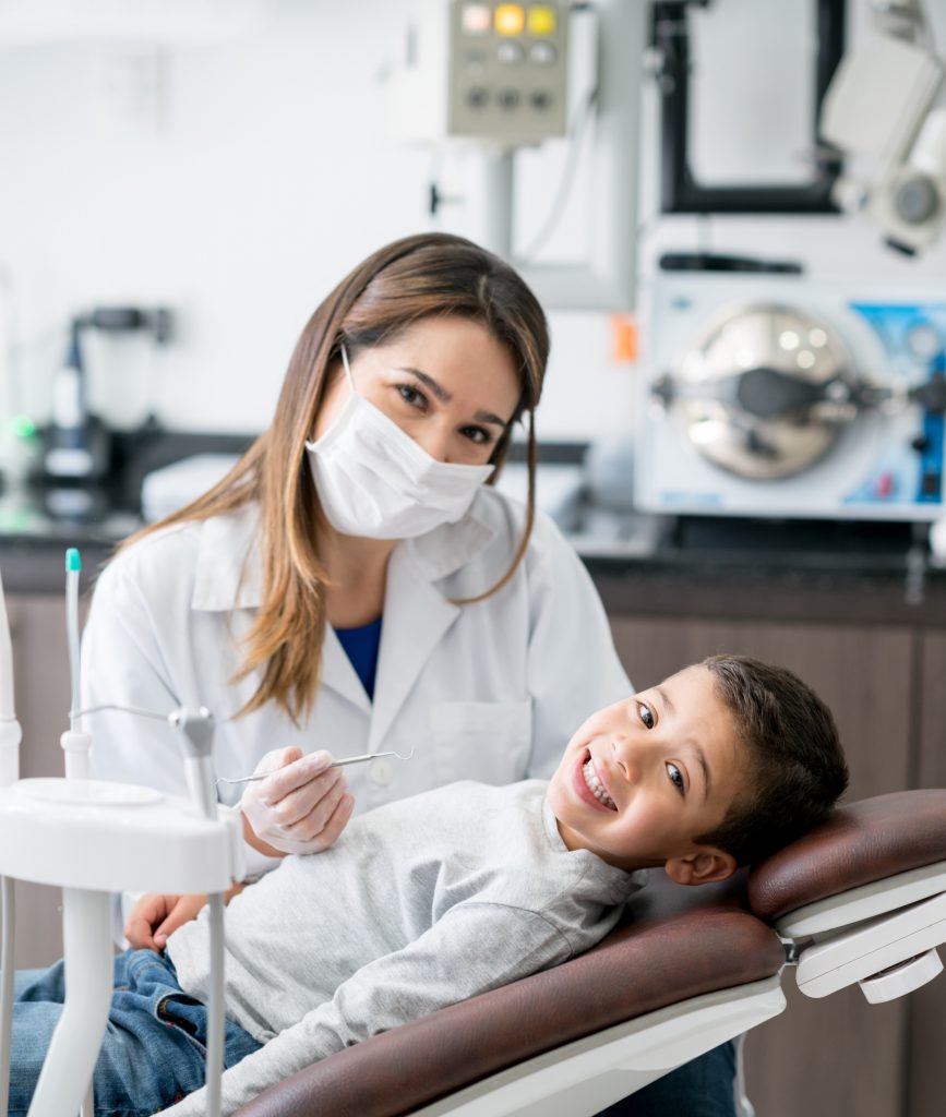 Niño y dentista, felices en consultorio