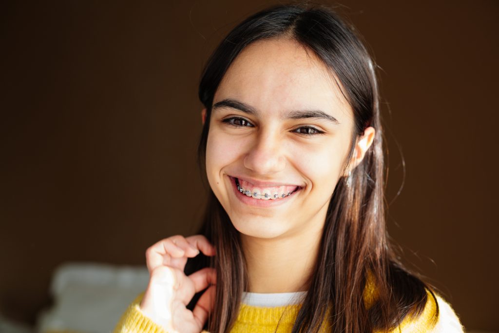Adolescente sonriendo, mostrando sus brackets autoligados